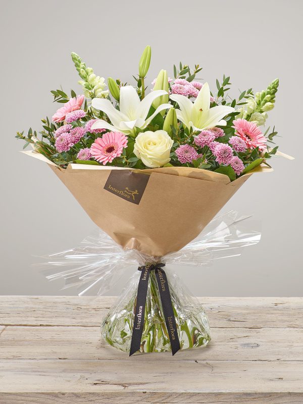 Hand-tied ‘Pure Pastels’ fresh flower arrangement. Includes, white LA lilies, Ivory Large Headed Roses, pink spray chrysanthemums, white antirrhinums and pink germini/