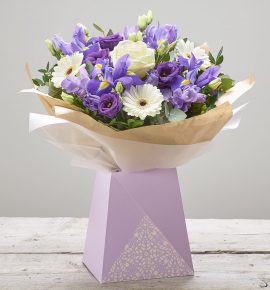 Bernard Chapman ’Amethyst Dusk’ flower bouquet presented in a pretty lilac gift box - Featuring ivory large headed roses, purple freesia, white germini, purple lisianthus and blue iris with pistache and eucalyptus. (Code: C14220BS)